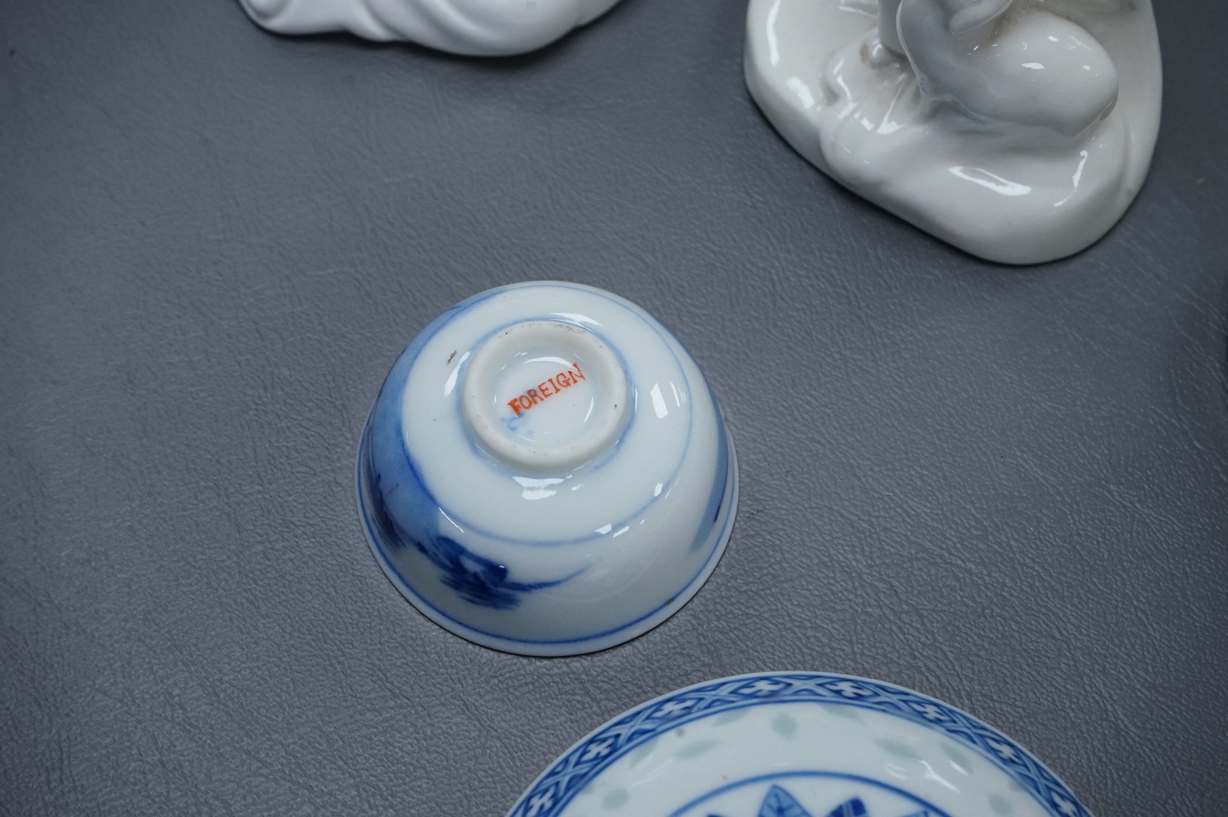 Four Chinese blanc de chine figures and two blue and white dishes and a model of a garlic bulb. Tallest figure 17.5cm.